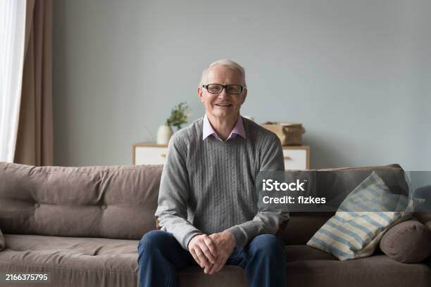 calm-retired-elderly-man-resting-seated-on-comfortable-couch